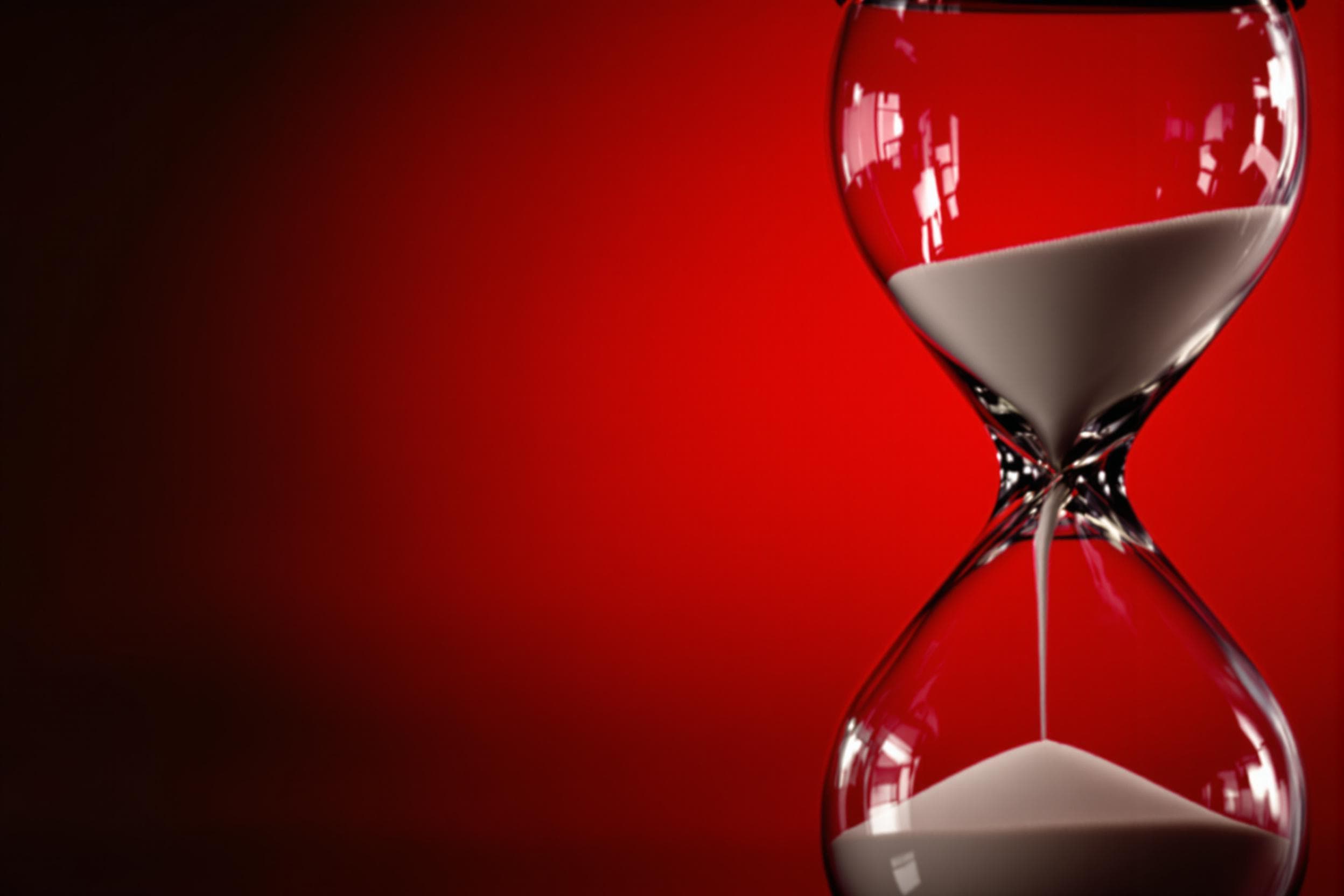 Suspenseful Hourglass on Red Backdrop